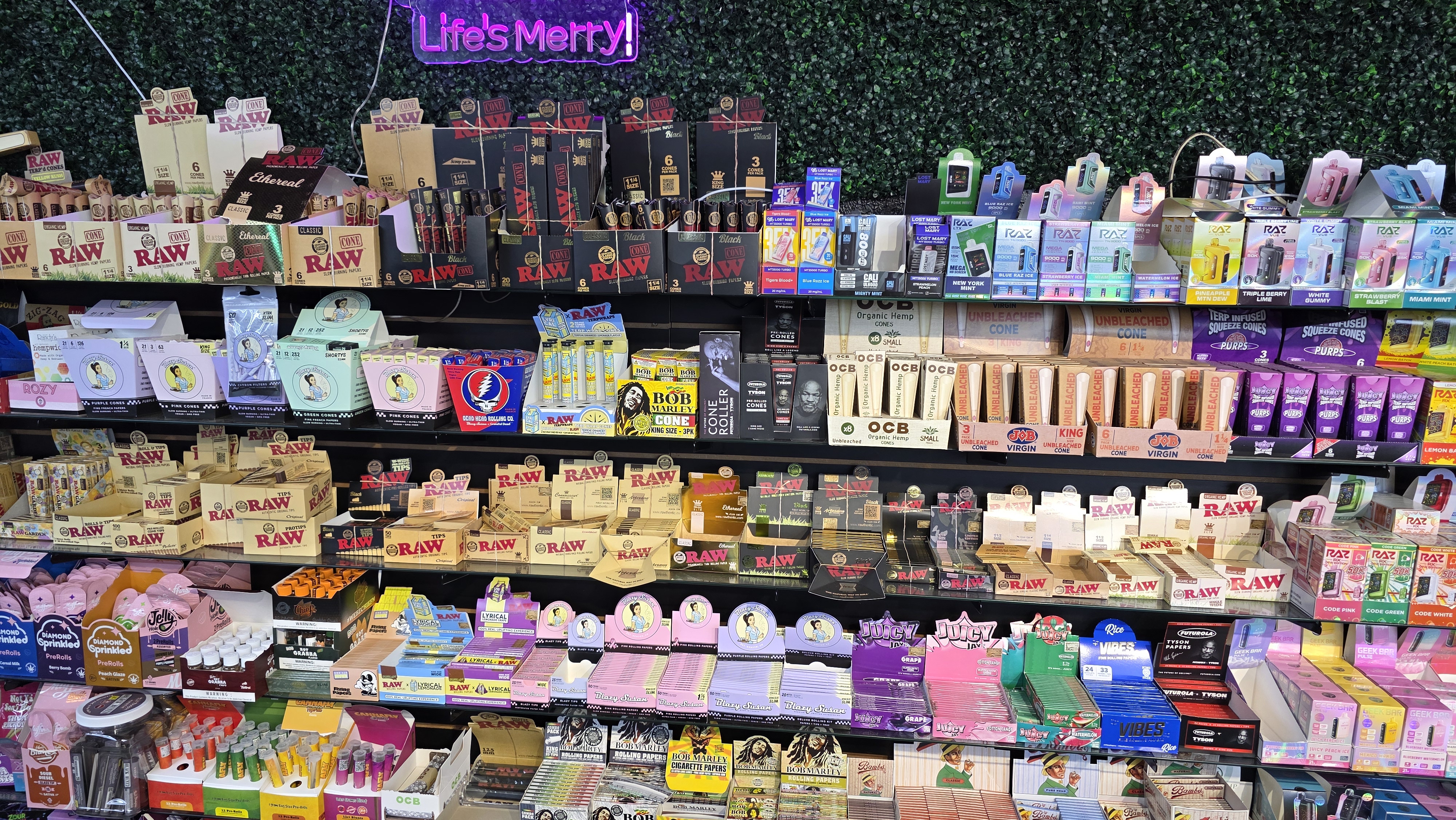 Rolling papers wall with Life's Merry neon sign